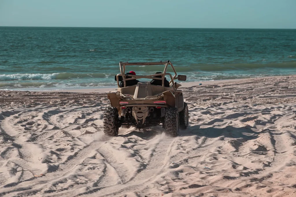 Off-road buggy driving on a sandy beach towards the Atlantic waves