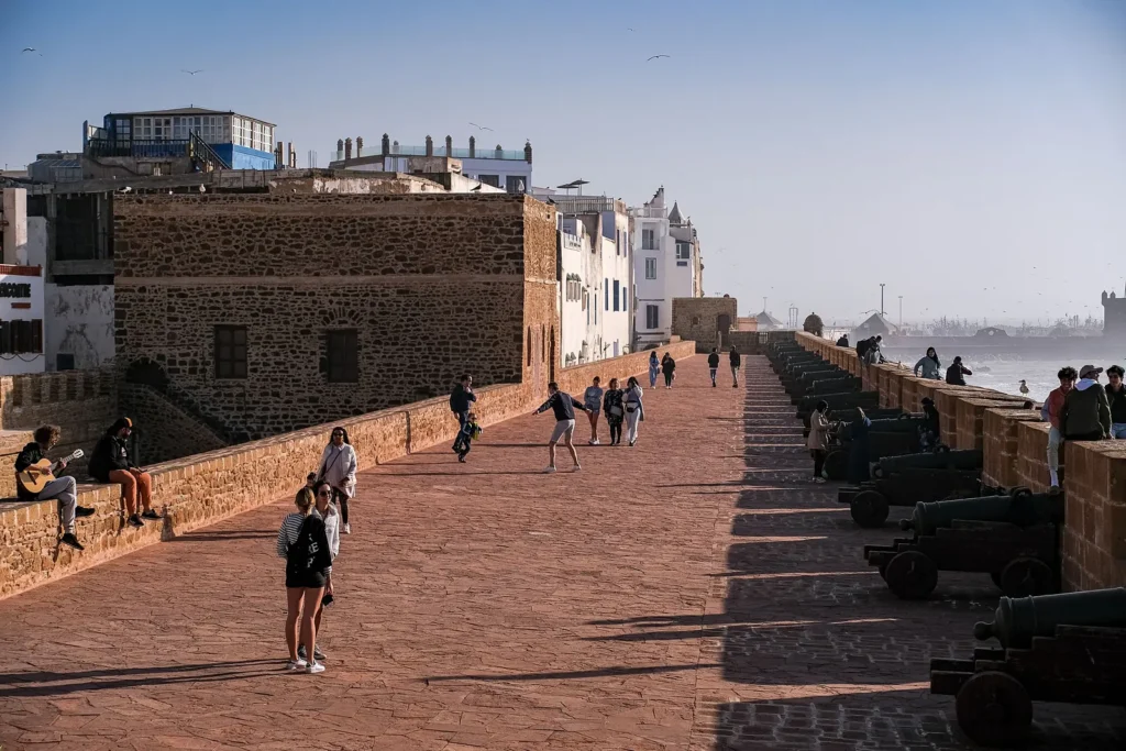 Visitors walking along the Skala ramparts of Essaouira beside old cannons