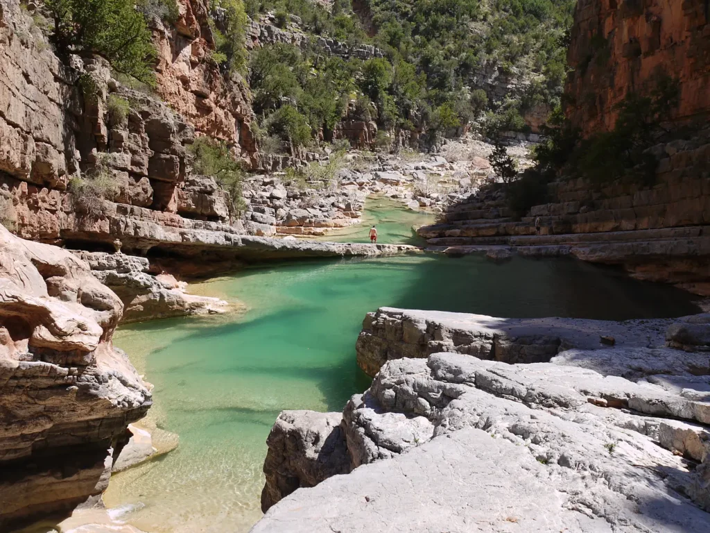 Turquoise natural pool between pale rocks in the Paradise Valley gorge