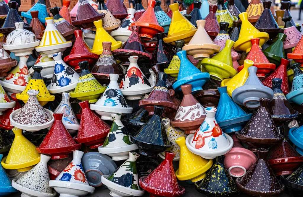 Rows of colourful painted tagine pots stacked at a Moroccan market stall