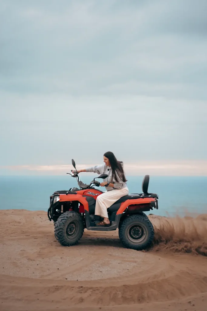 Quad bike turning on the sand with the ocean behind