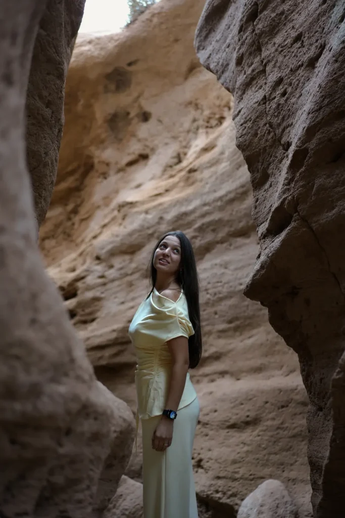 Visitor between the curved walls of a narrow sandstone canyon